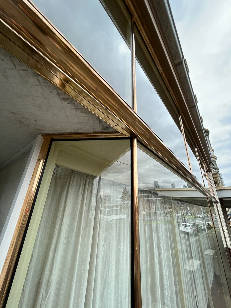 Copper-framed shopfront window viewed along its corner and upper frame